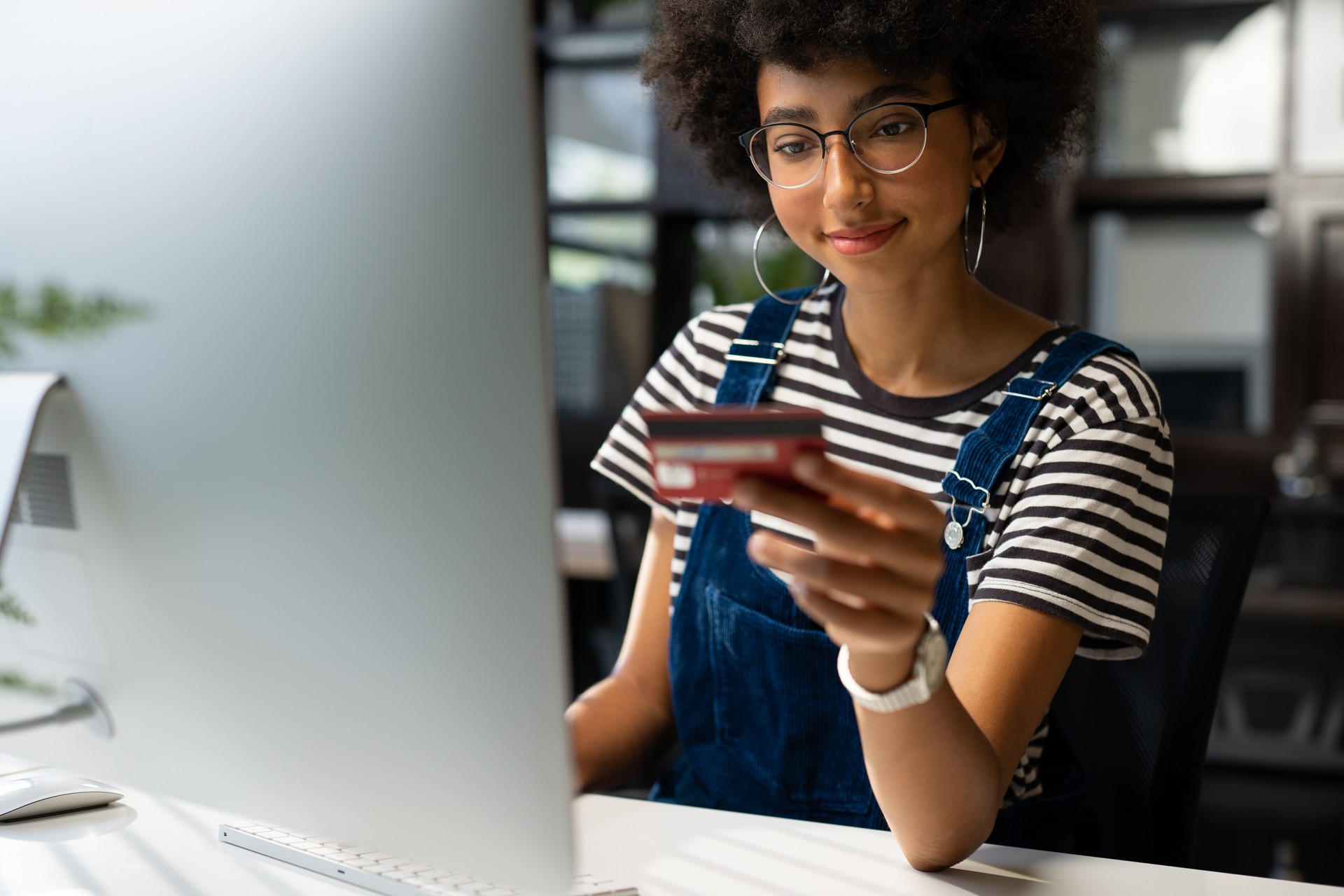 teenage girl looking at credit card and computer